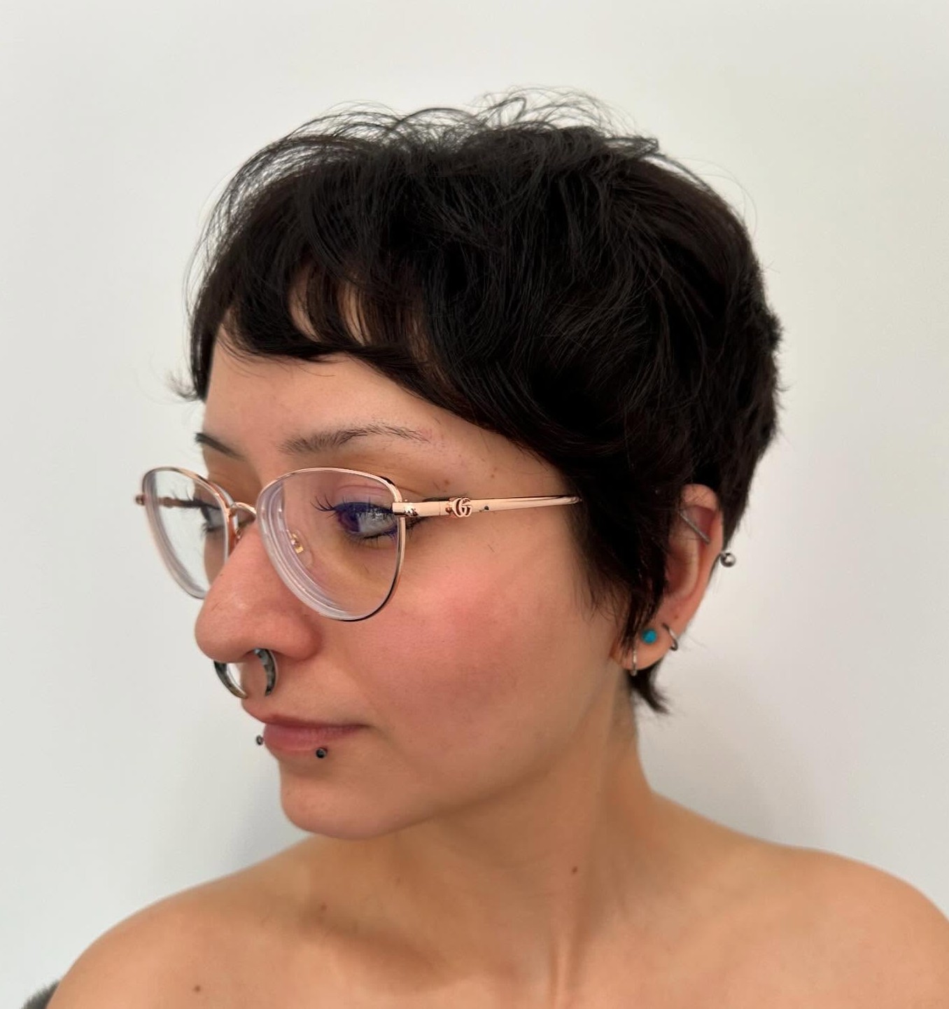 Curly Dark Pixie Cut with Messy Texture Accented by Glasses and Piercings