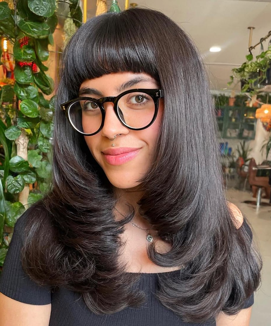 Sleek Dark Layered Hair with Thick Straight-Across Bangs and Glasses