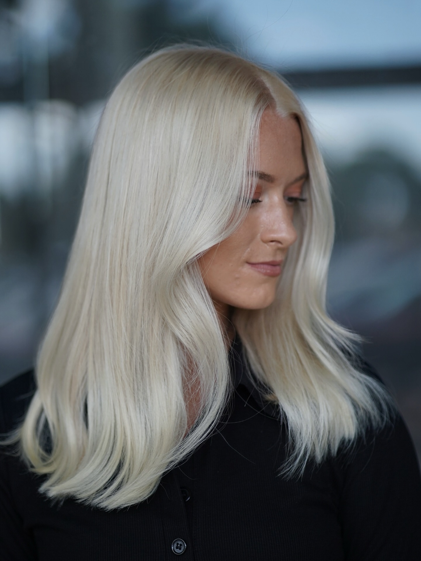 Smooth Straight Platinum Blonde Haircut with Subtle Turned Ends Side View