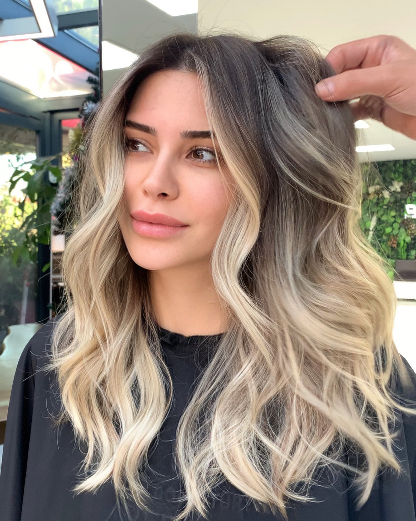 Woman with Beautifully Blended Balayage Hair Looking Away during a Stylist Consultation