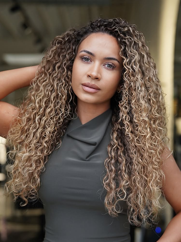 Full Voluminous Curly Hair with a Soft Shadow Root and Golden Highlights