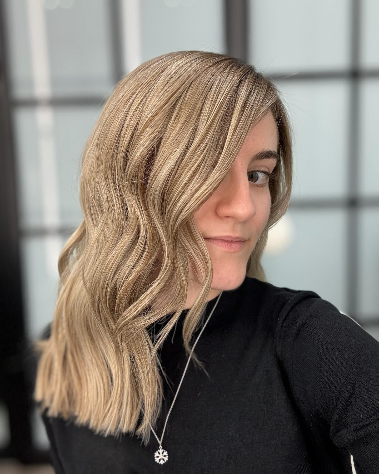 Soft Wavy Sandy Blonde Medium Haircut with Elegant Side-Swept Bangs