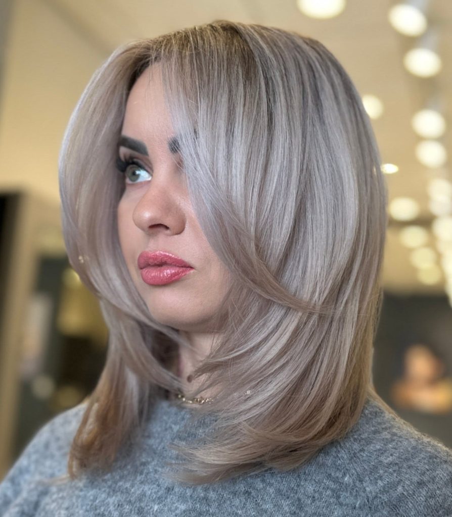 Shoulder-Length Layered Haircut on Straight Hair with a Center Part and Polished Finish