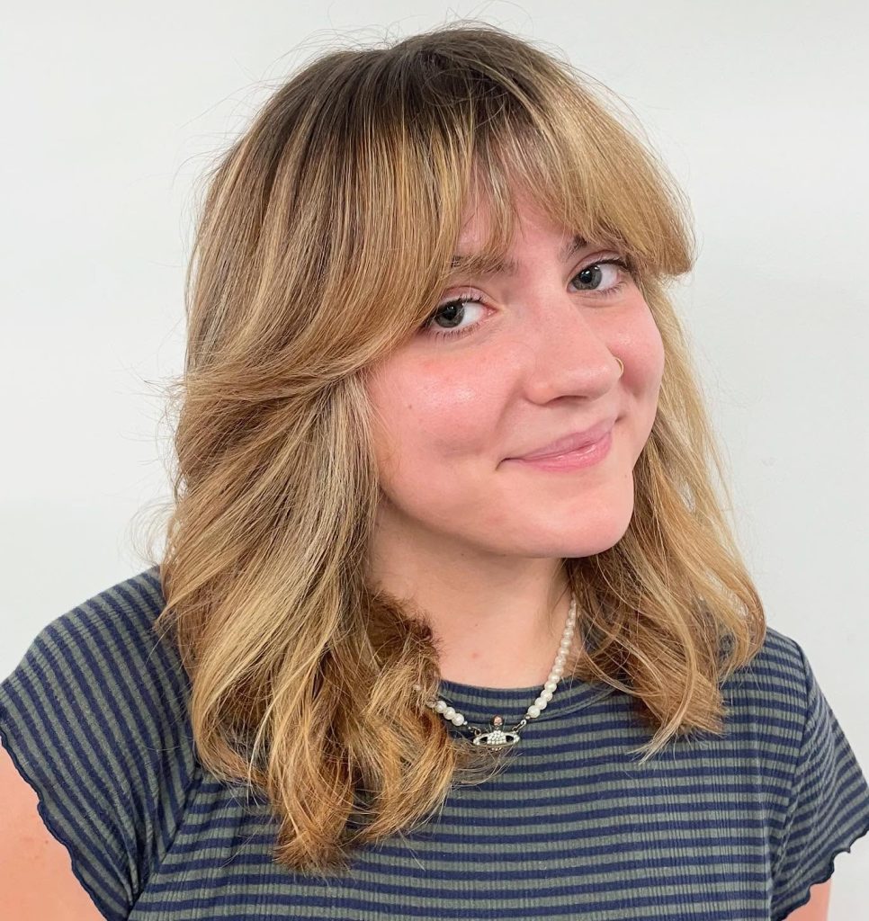 Medium-Length Layered Haircut with Curtain Bangs and Soft Waves