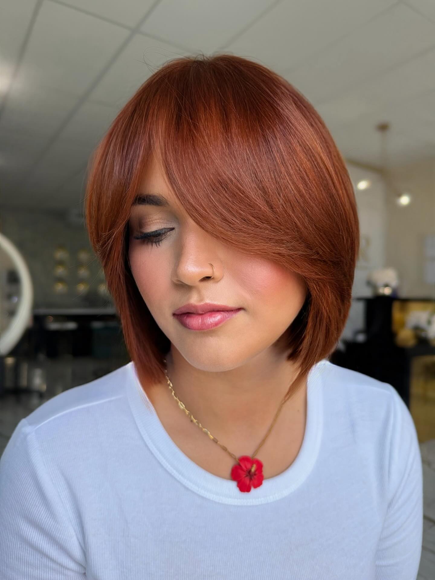 Smooth Auburn Copper Bob with Curved Face-Framing Layers and Side-Swept Bangs