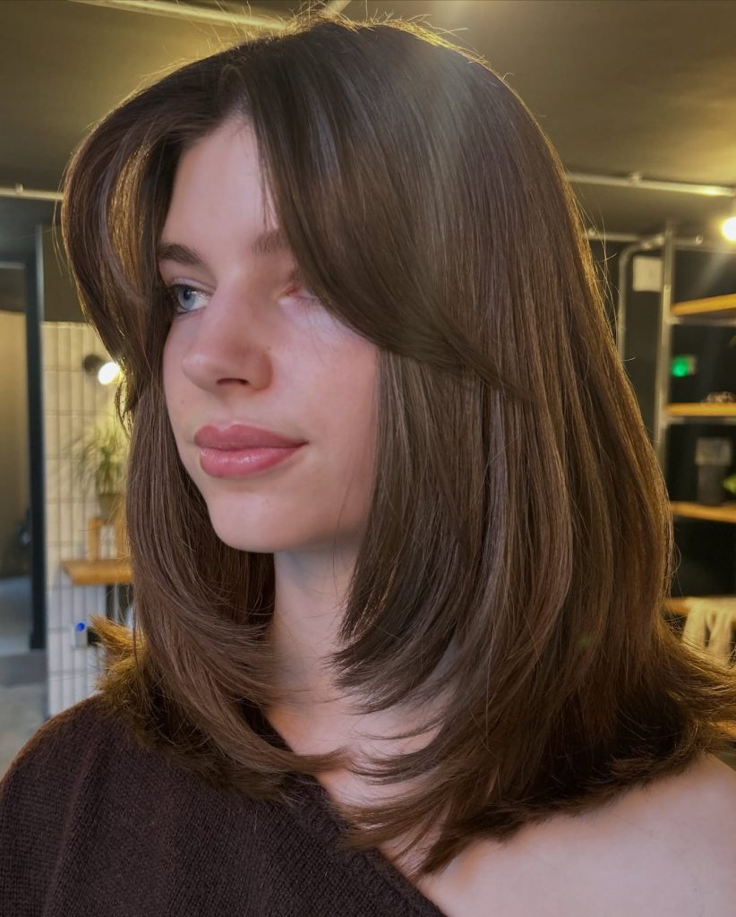 Shoulder-Length Layered Haircut with Curtain Bangs Framing the Face