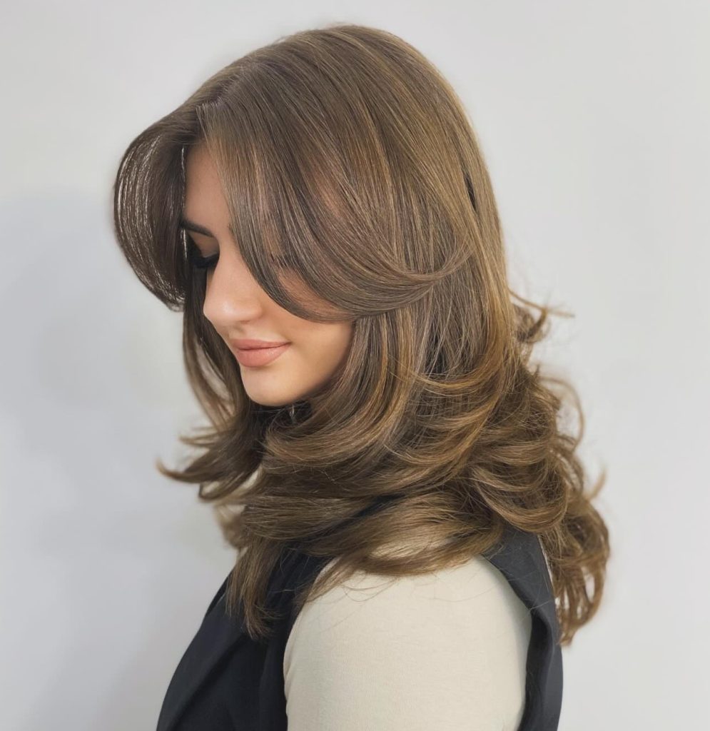 Stylist Consultation for a Butterfly Haircut Showing Reference Photos in Salon
