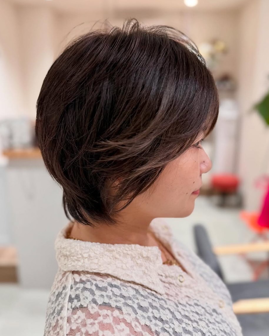 Side Profile of a Short Dark Brown Layered Haircut with Soft Volumizing Layers