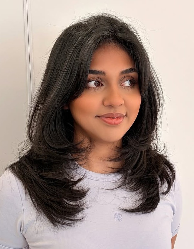 Medium-Length Dark Layered Haircut with Textured Ends and Soft Curtain Bangs