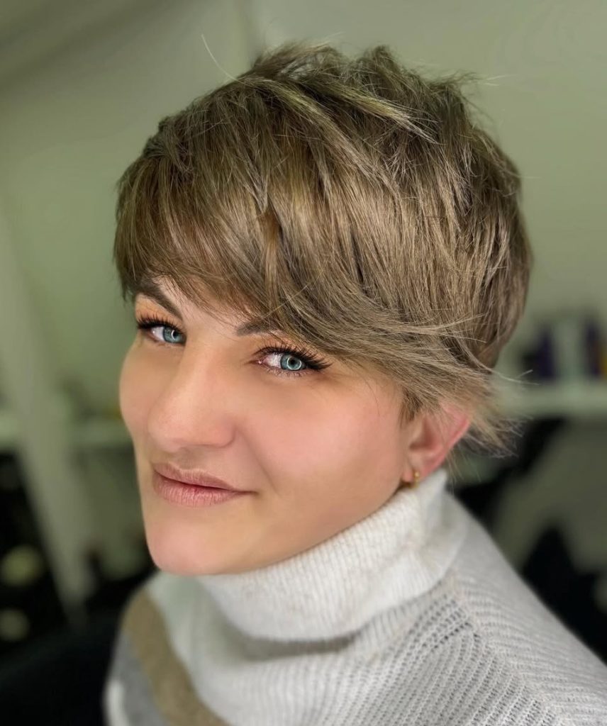 Short Pixie with Long Side-Swept Bangs Angled Across the Forehead on Blonde Hair