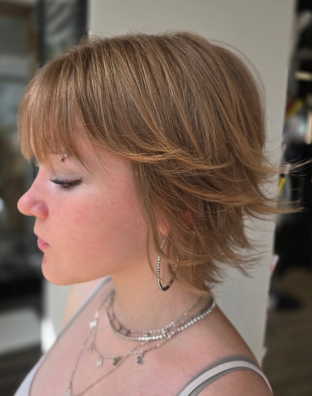Short Light Brown Shaggy Haircut with Wispy Curtain Bangs and Flicked Ends
