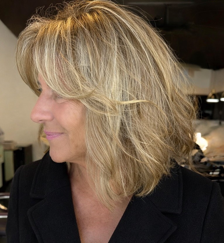 Side Profile of Textured Medium Blonde Haircut with Layers
