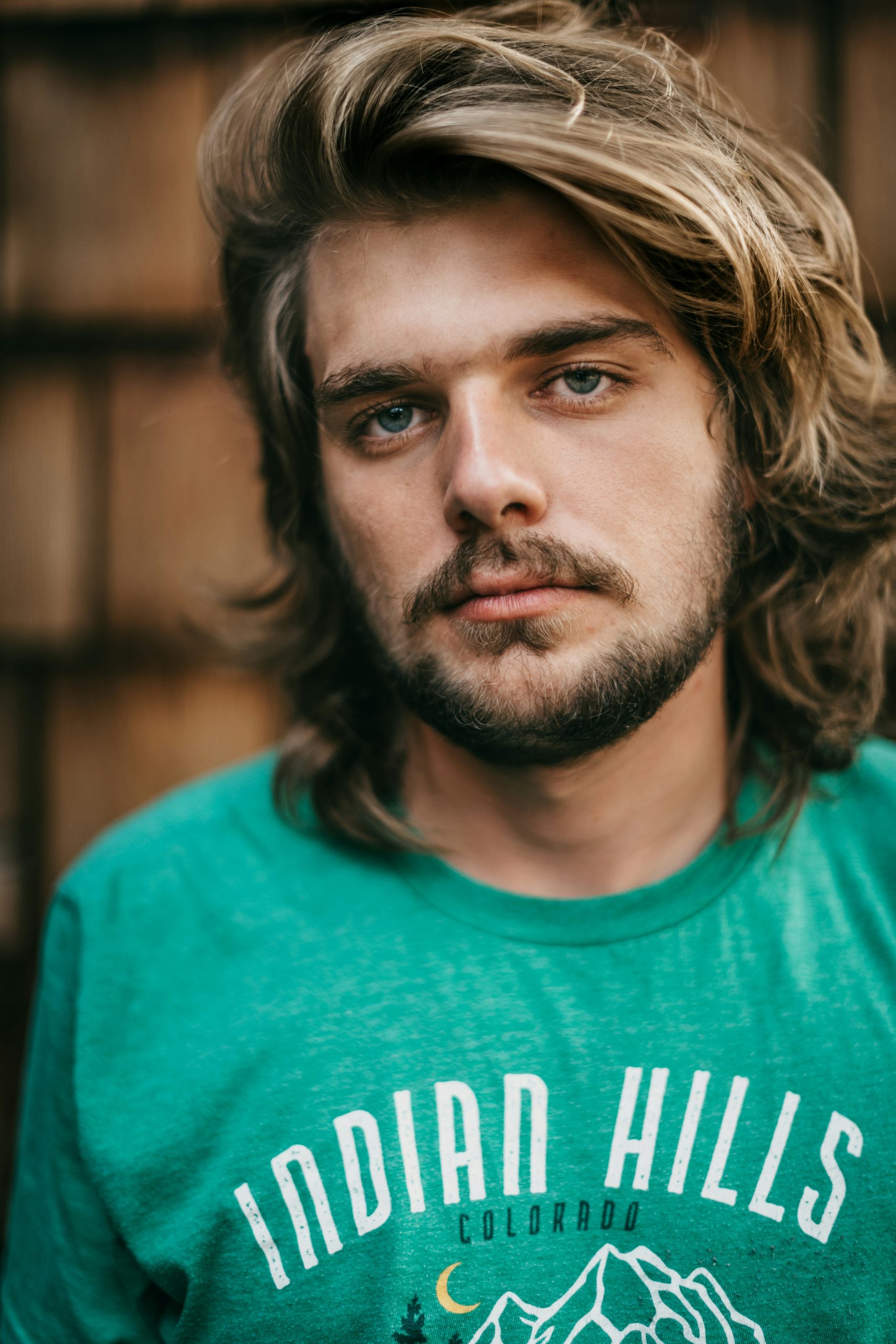 Flow Haircut on a Man with Medium-Length Wavy Hair Swept Back behind the Ears in Natural Movement