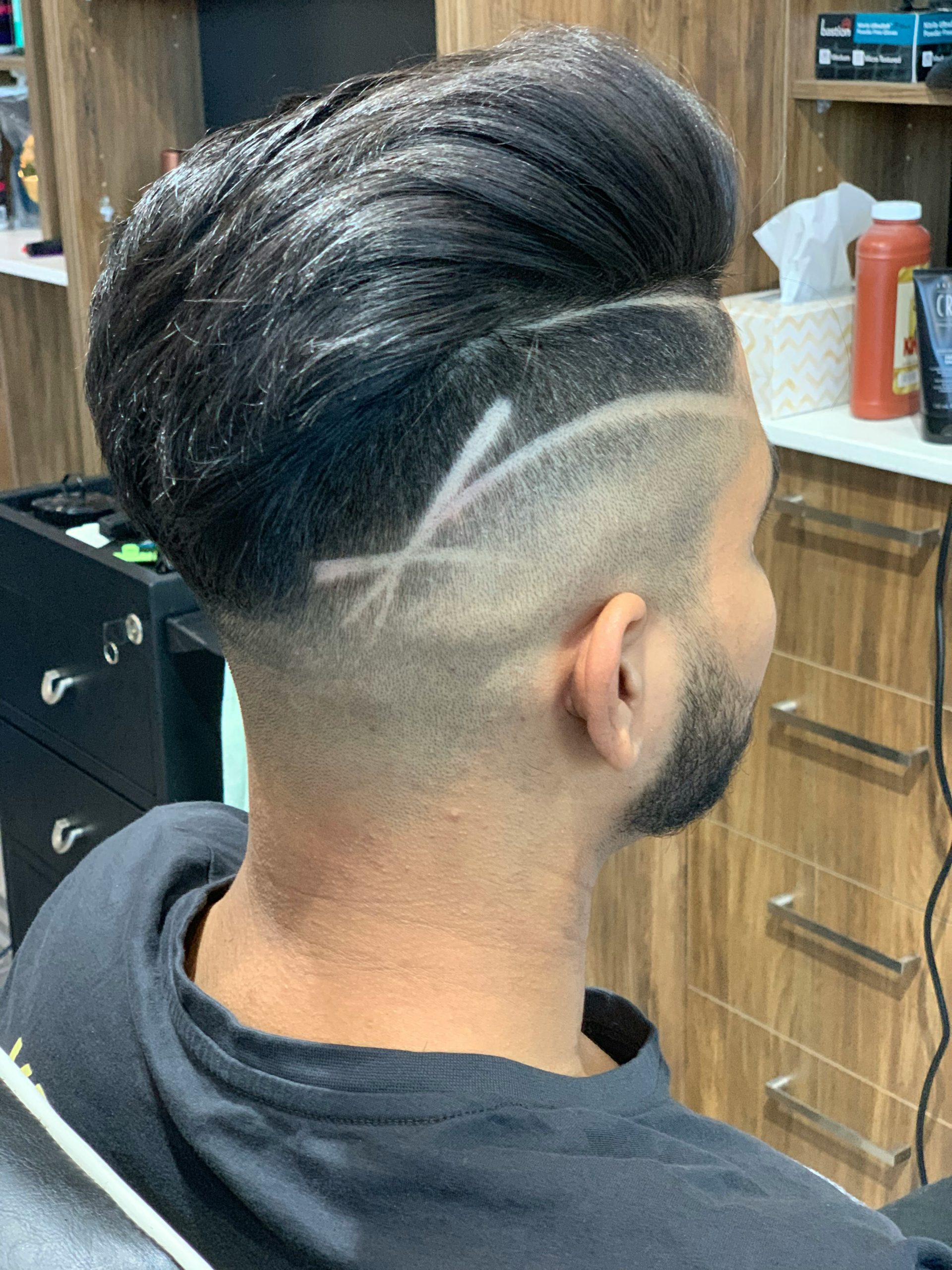Haircut Design with Sharp Razored Lines Etched into a Faded Side over Short Dark Hair