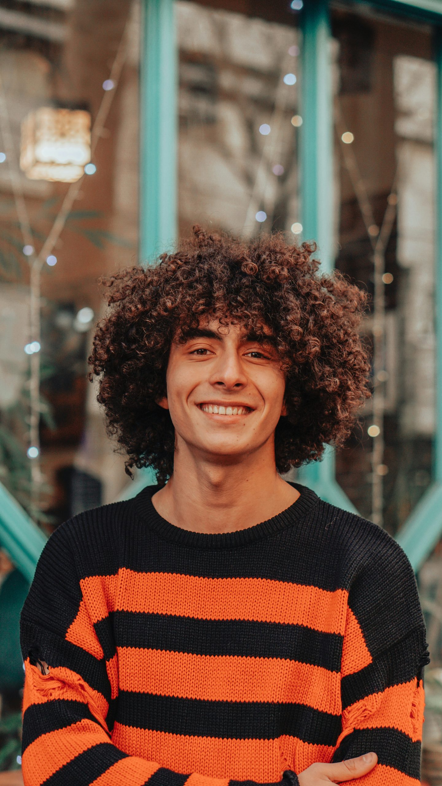 High Taper Fade for Curly Hair on a Man with Tall Defined Curls and a Bold Fade Starting above the Temples