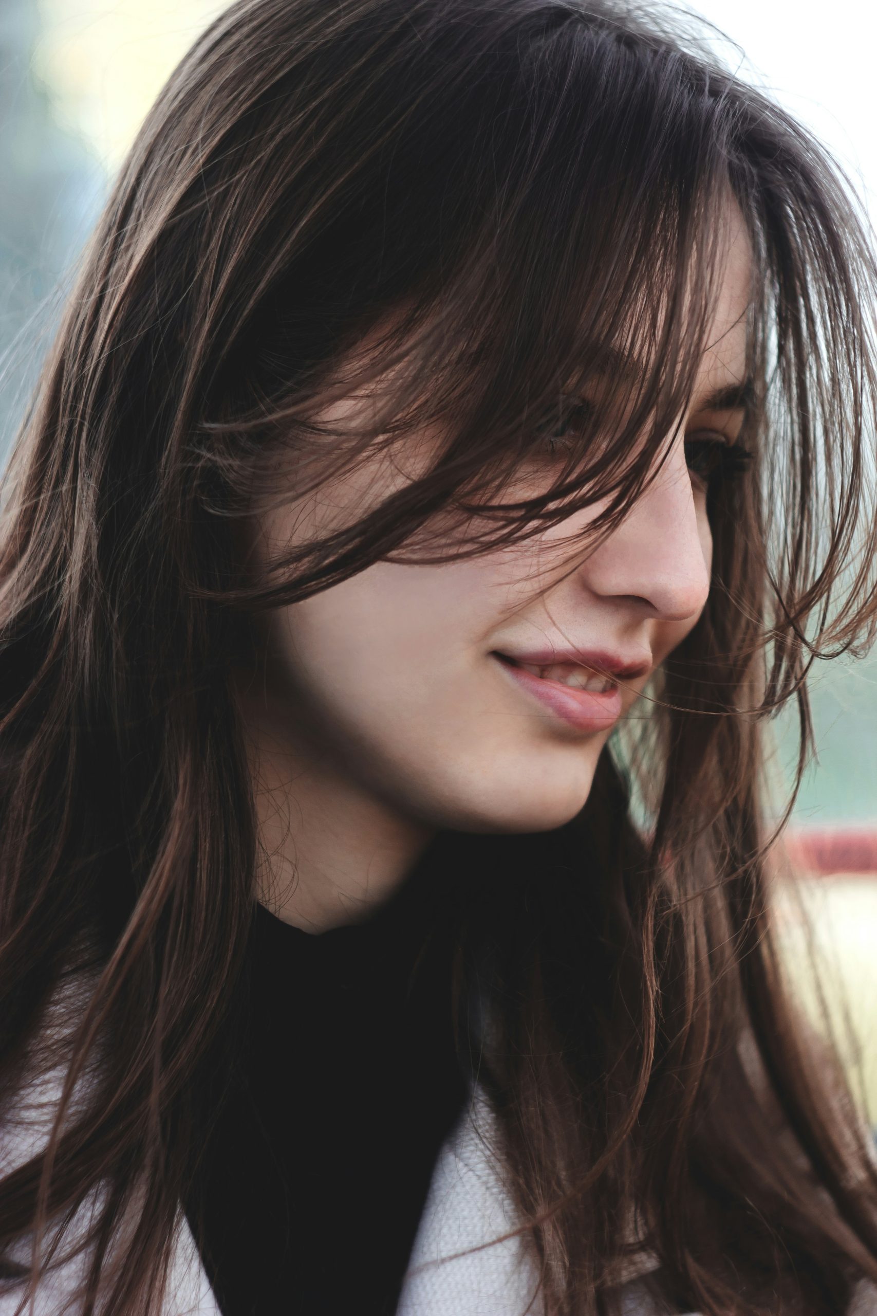 Long Shag Haircut with Heavy Choppy Layers and Curtain Bangs Falling past the Shoulders on Wavy Brunette Hair