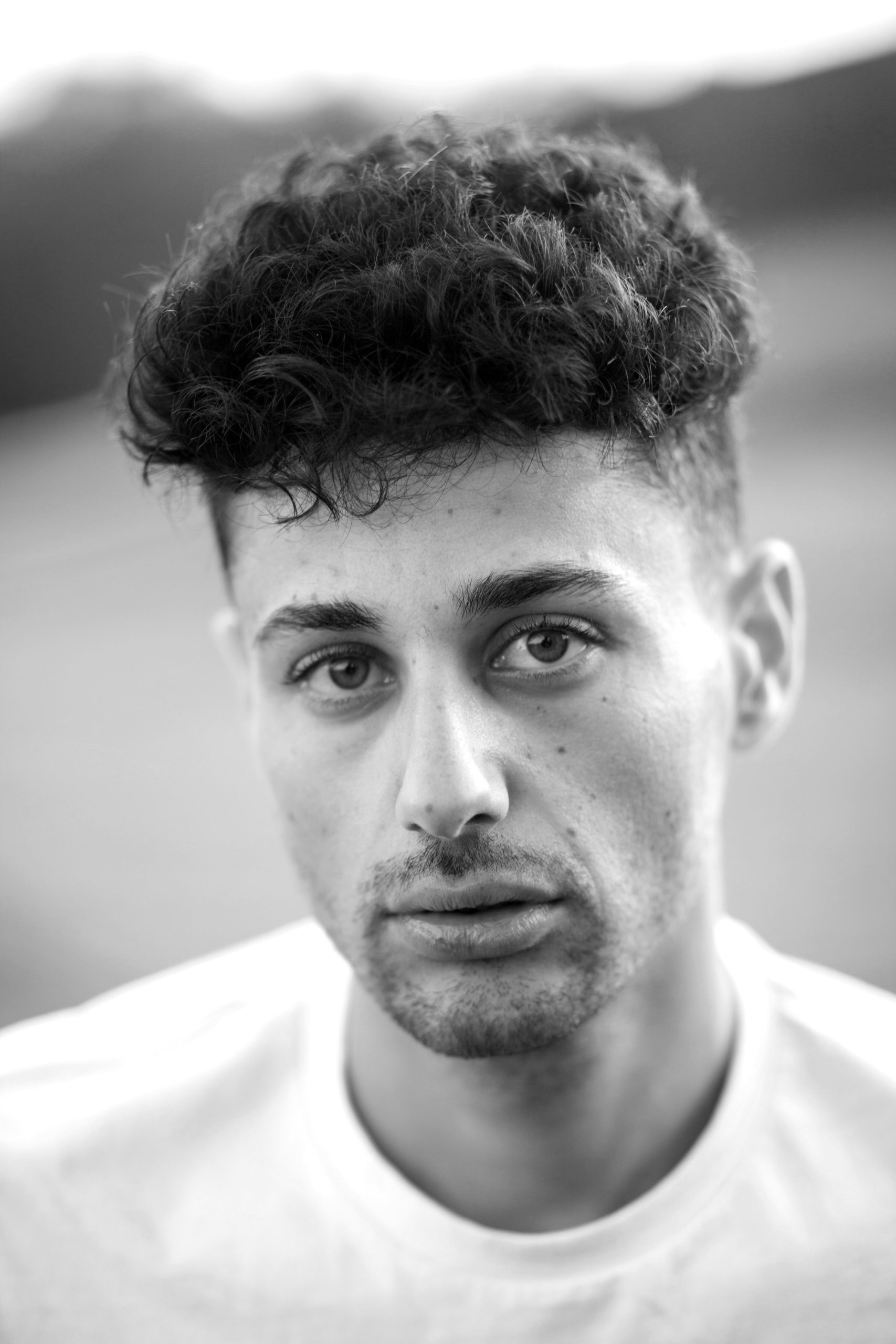 Low Fade for Curly Hair on a Man with Defined Type 3 Curls on Top and a Clean Faded Hairline