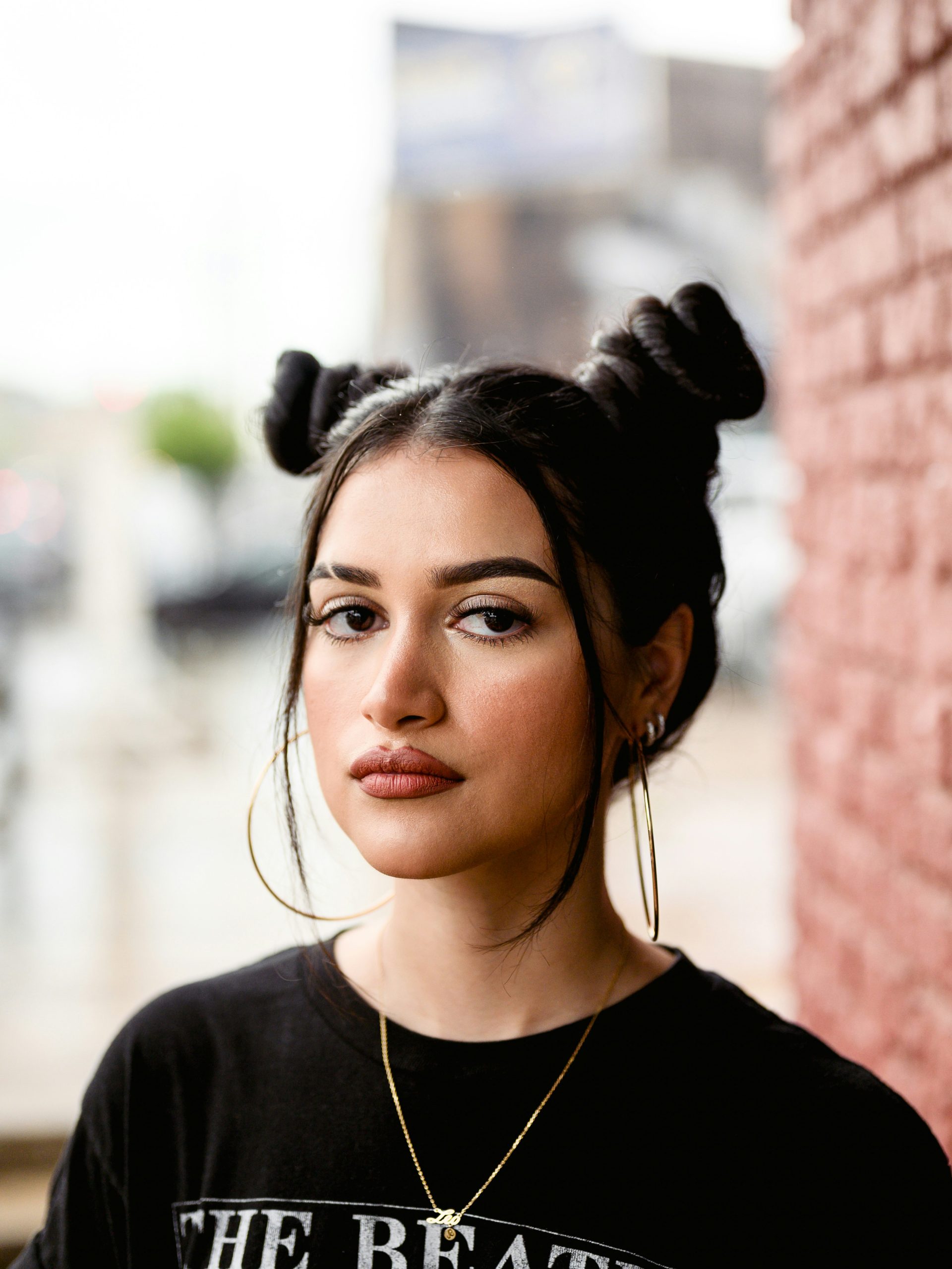 Space Buns Hairstyle with Two High Symmetrical Buns and a Clean Center Part on Long Wavy Hair