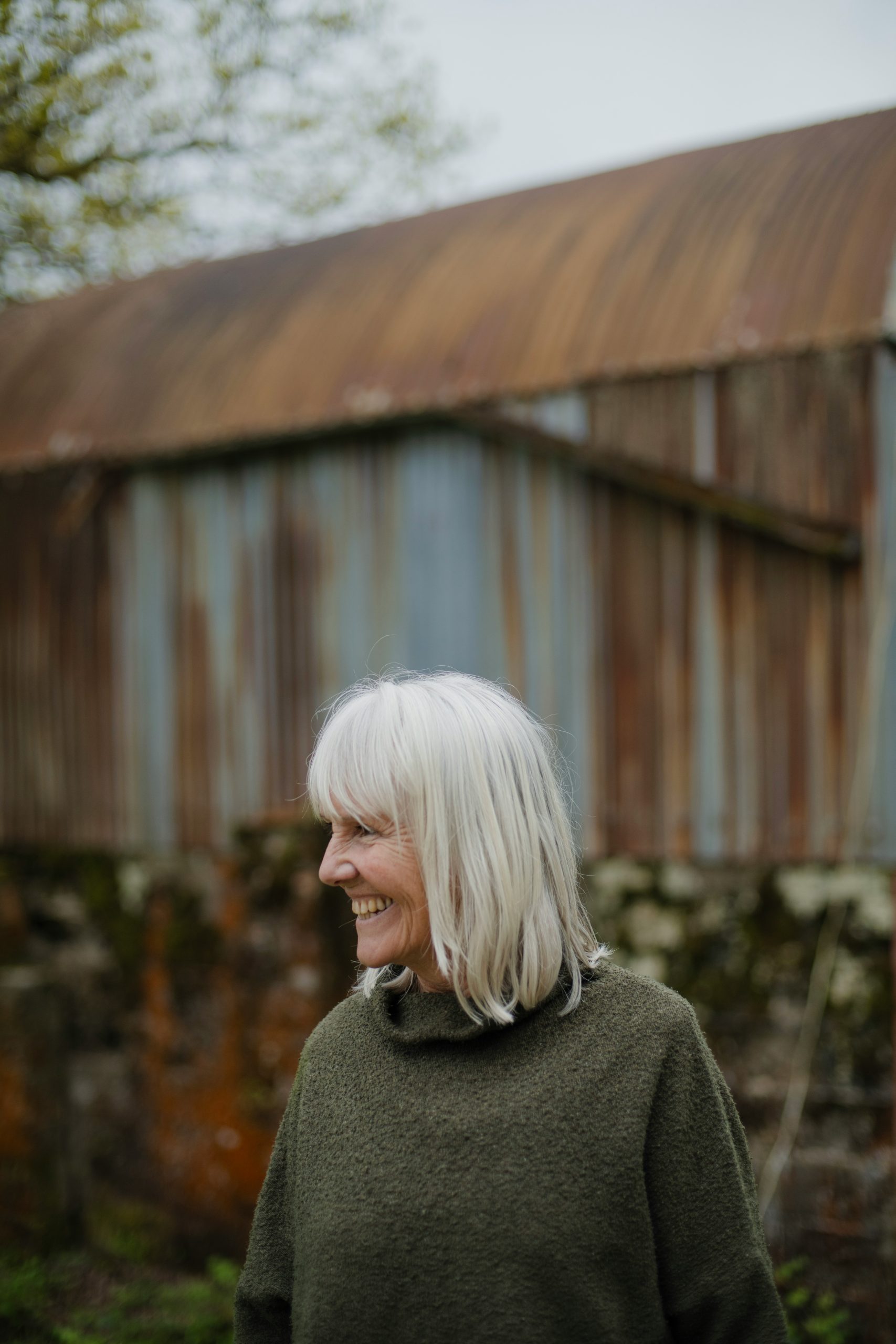Woman Over 60 with Soft Curtain Bangs on a Layered Silver Bob