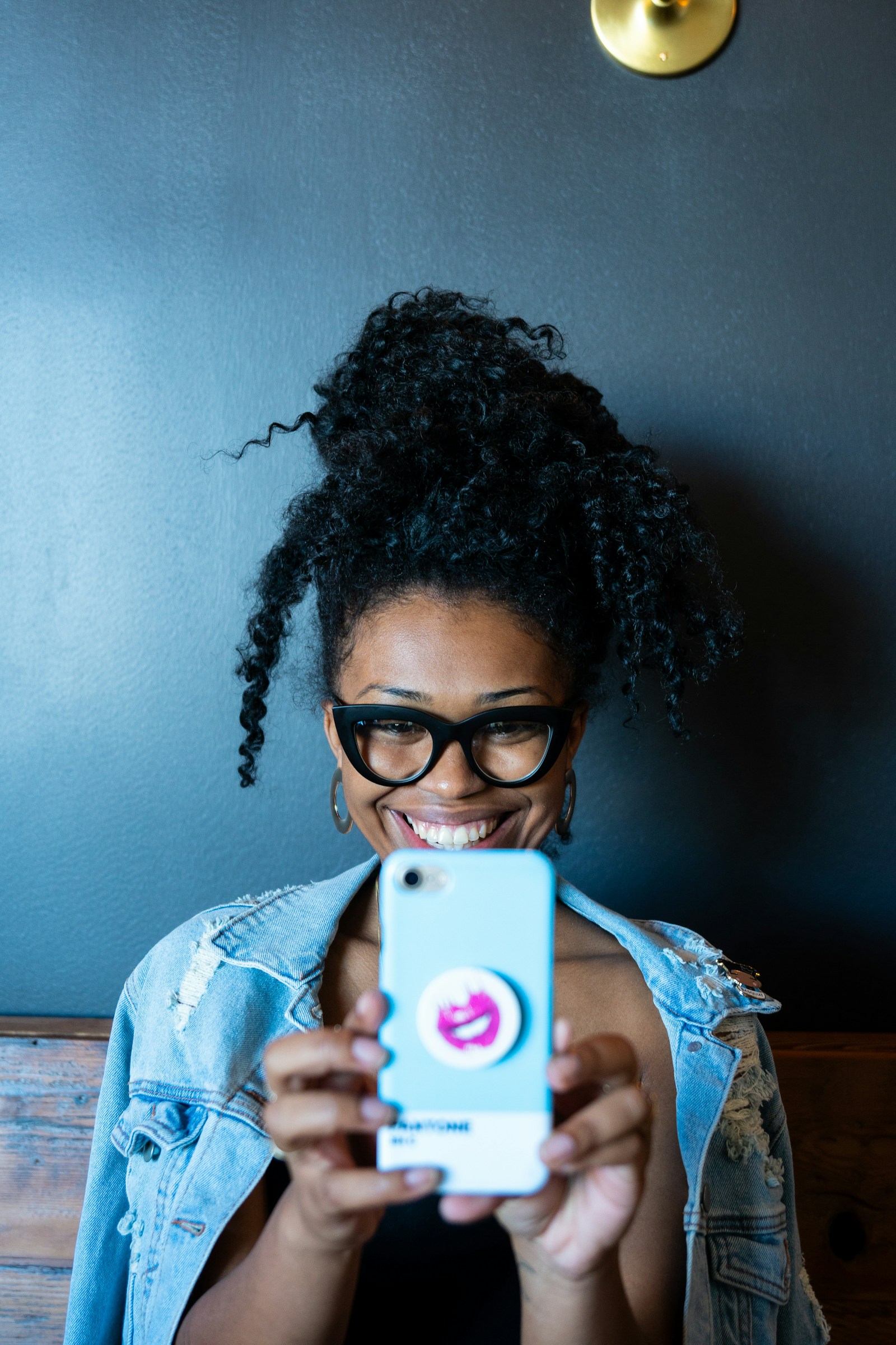 Show Inspo Photos at the Salon Woman Holding Her Phone with a Hairstyle Reference Photo During a Salon Consultation