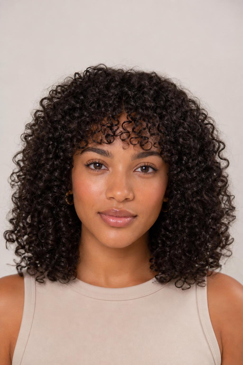 Curly Arched Fringe Cut Dry Along a Rounded Line on Dark Spiral Curls