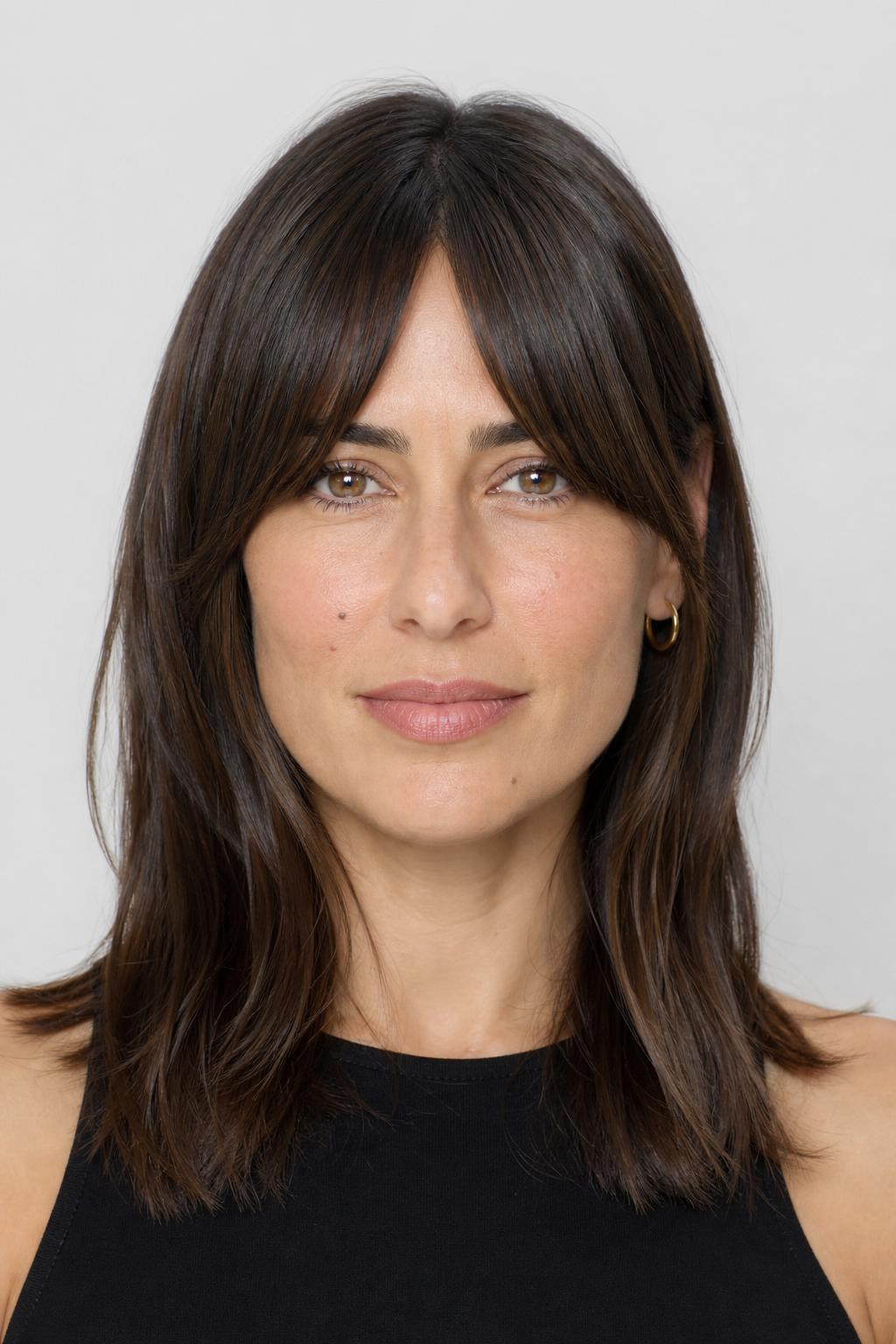 Arched Bangs Flowing into Cheekbone-Length Face-Framing Pieces on Brunette Hair