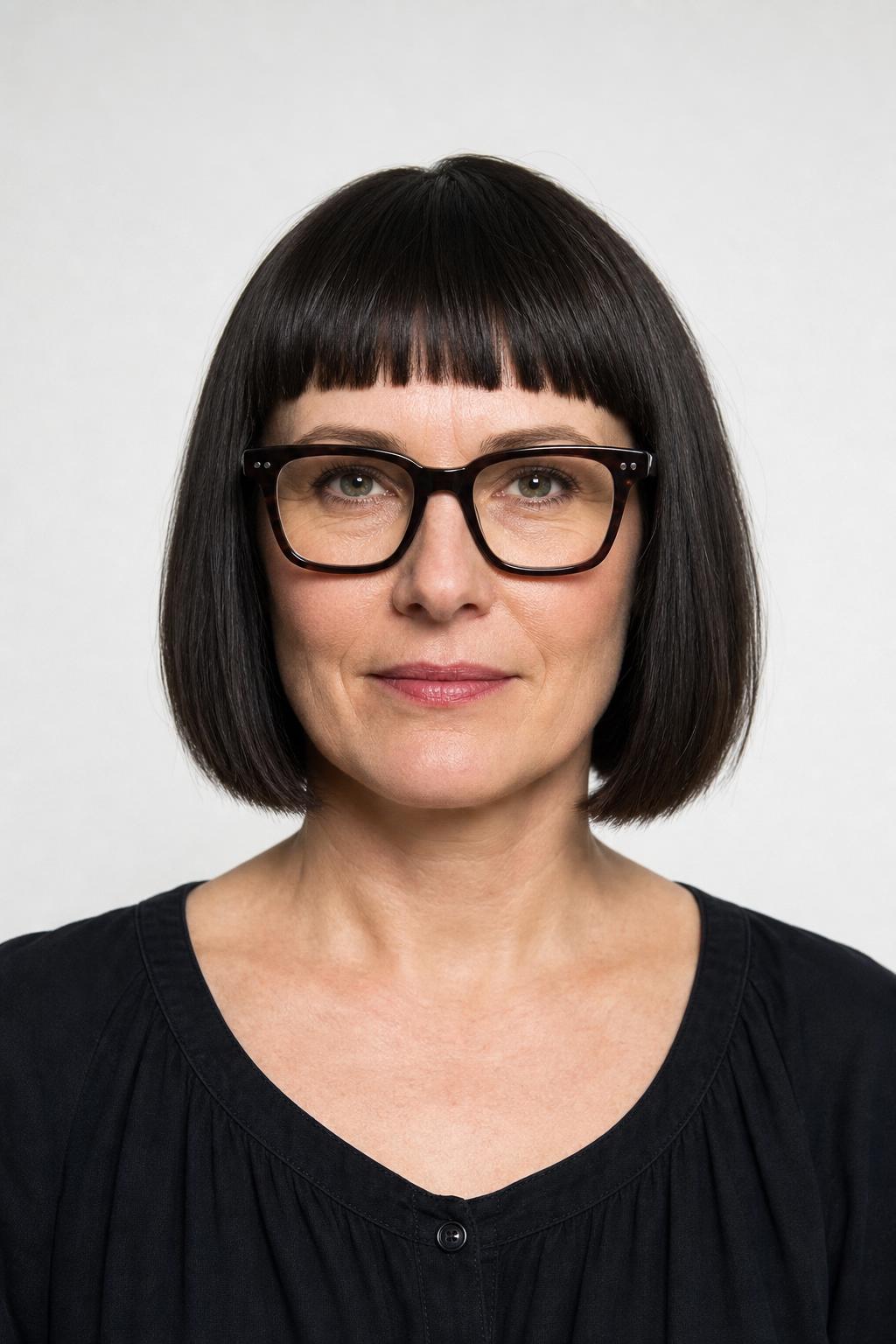 Blunt Bangs and Jaw-Length Bob Echoing Square Dark Frames