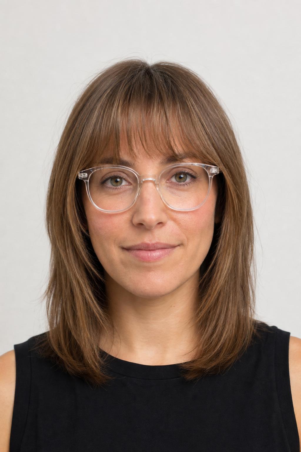 Feathered Wispy Bangs Above Clear Acetate Frames on Light Brown Hair