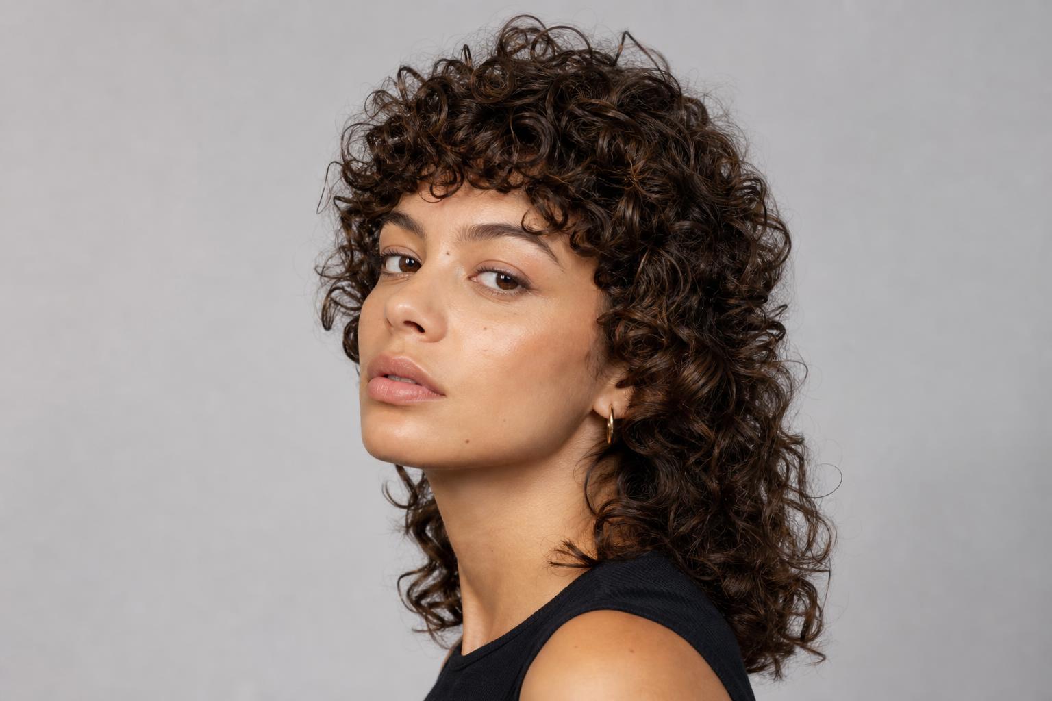 Curly Mullet with Short Crown Layers and Longer Curls at the Nape