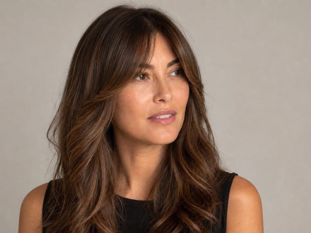 Soft Center-Parted Curtain Bangs Blending into Long Layers on Wavy Brunette Hair