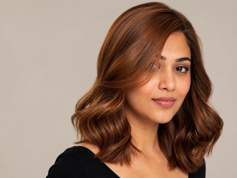 Golden Auburn Hair with Warm Red-Brown Depth and Bright Golden Shimmer on Loose Glossy Waves