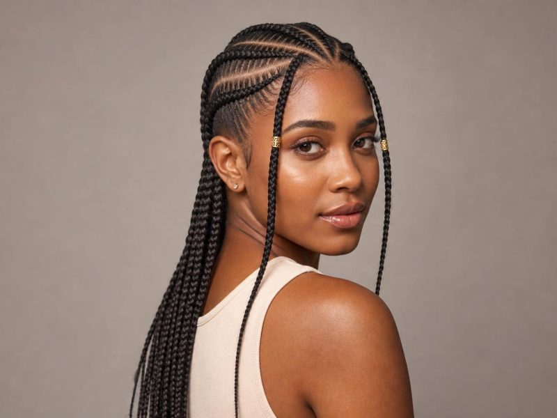 Fulani Braids with a Center Cornrow and Gold Cuffs on Long Dark Braids