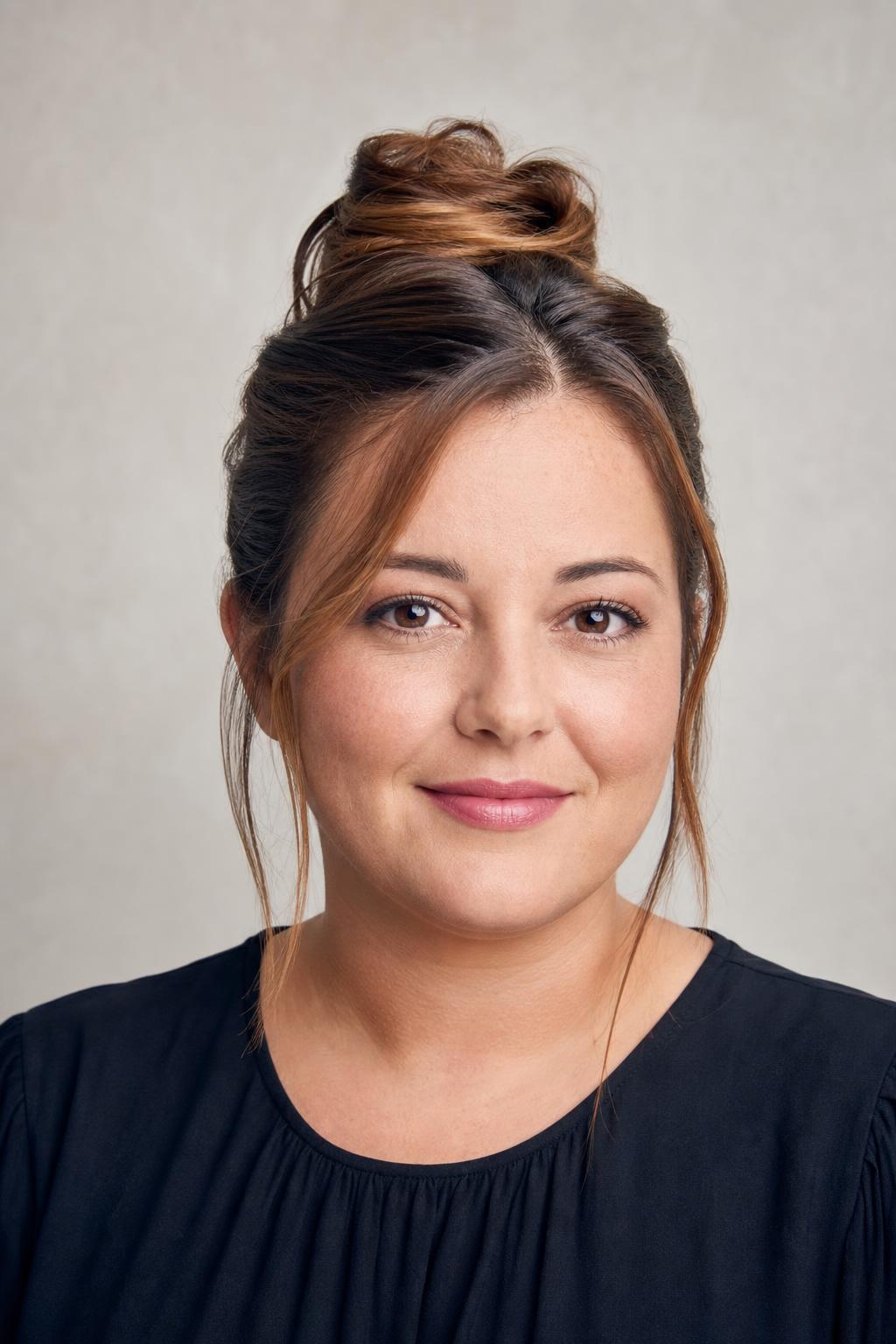 Mid-Height Bun Set Above the Crown with Loose Temple Pieces on Brown Hair
