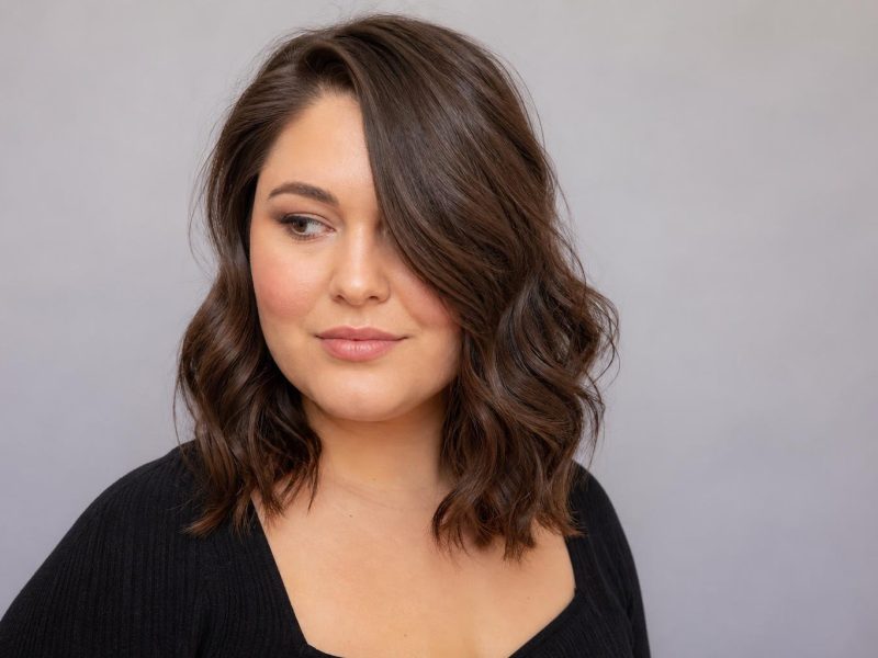 Deep Side Part Hairstyle With Soft Waves on a Round Face