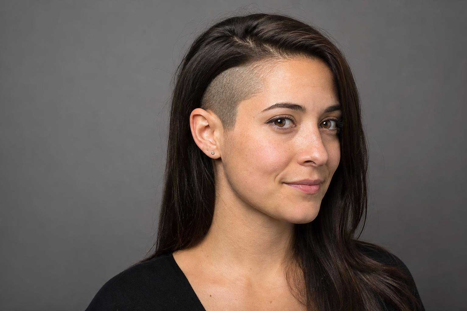 Long Dark Hair Tucked behind the Ear to Reveal a Curved Clipper-Shaved Undercut Panel